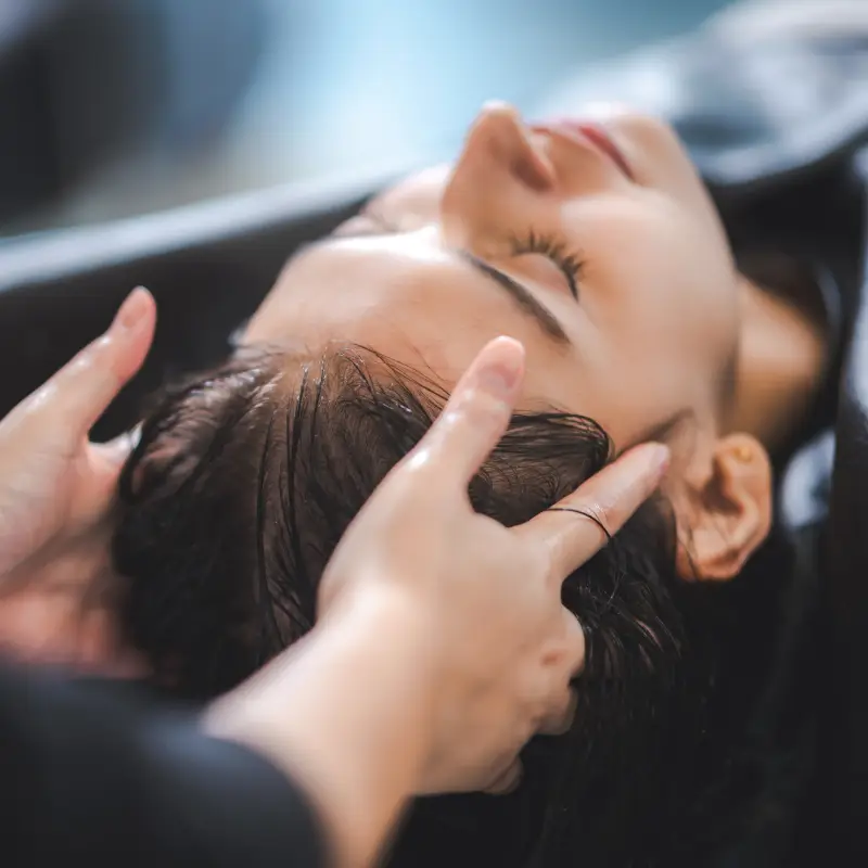 Cliente recebendo tratamento capilar no Beauty.co.lab, com foco no cuidado do couro cabeludo e revitalização dos fios.