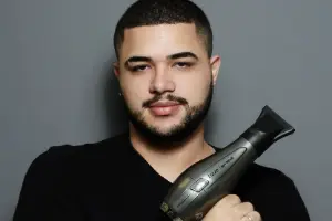 Davi Moraes segurando um secador profissional, pronto para finalizar um look no Beauty.co.lab.