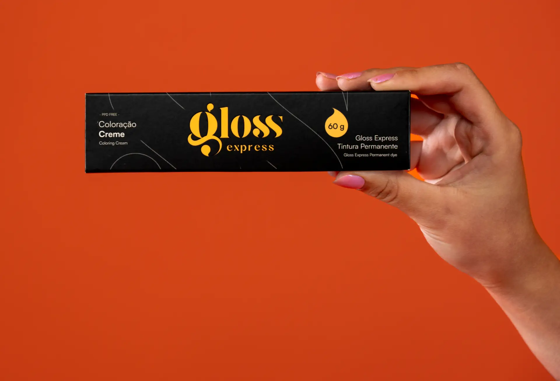 Mão feminina segurando a caixa da coloração Gloss Express em um ambiente de salão, destacando sofisticação, cuidado e escolha consciente para cabelos brancos.