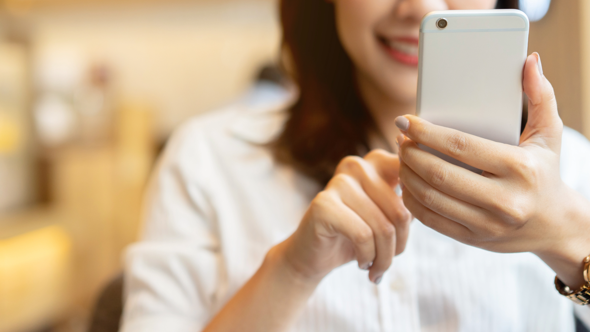 Mulher agendando podologia pelo celular, com a tela de app/WhatsApp em destaque