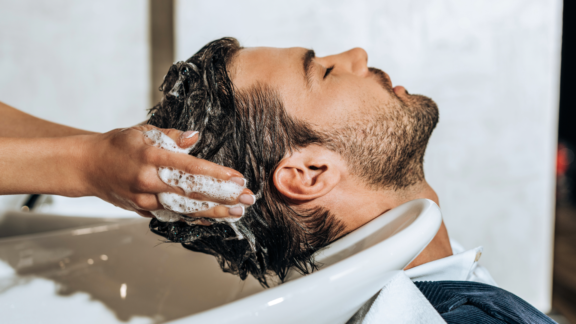 Homem recebendo lavagem capilar no lavatório do Beauty.Co.Lab, durante o Ritual Homme.